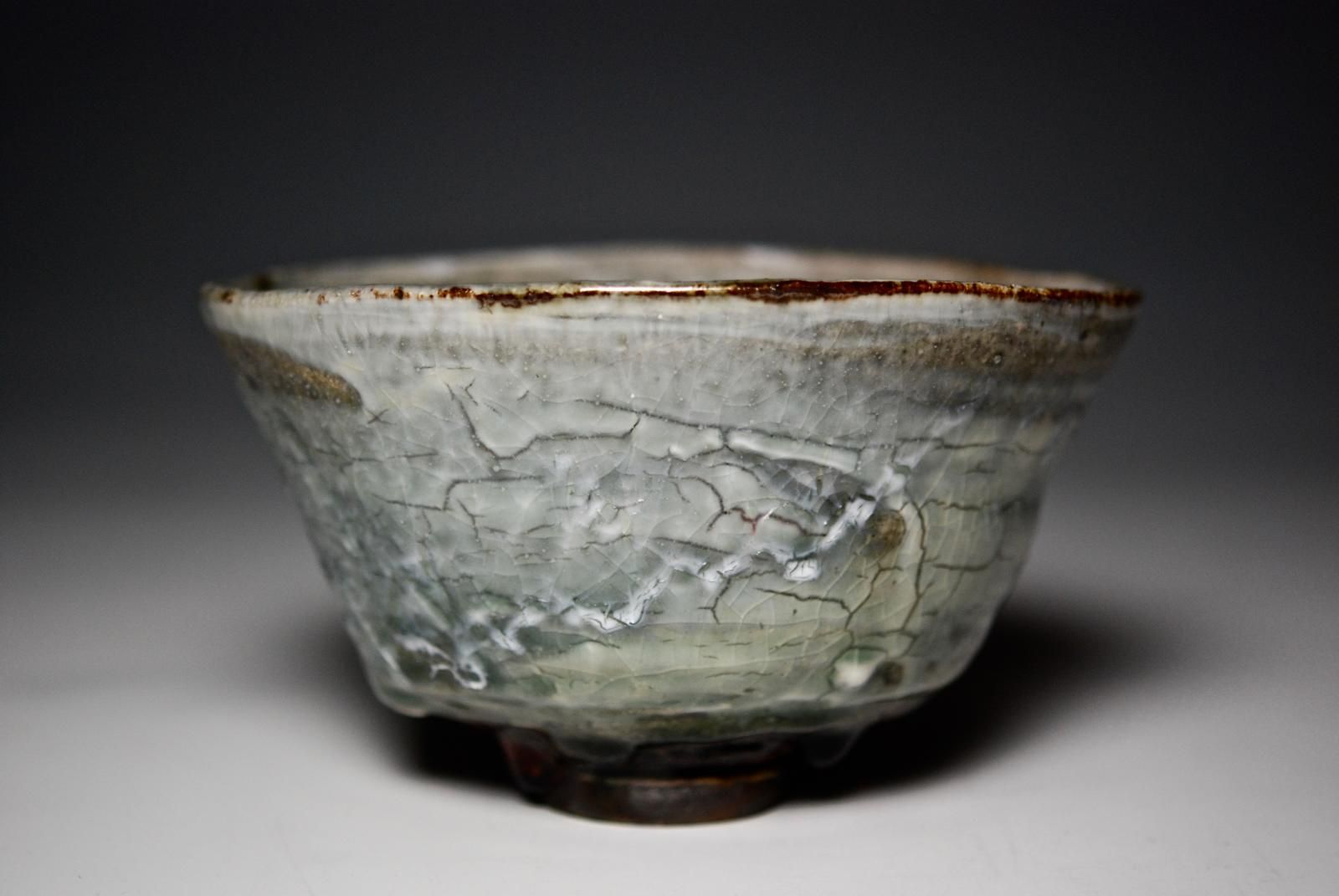 Wheel thrown Chawan, using black clay with celadon and copper oxide glaze, and a frosted over glaze.  Fired in a reduction atmosphere in an oil fuelled kiln. by Margaret Curtis